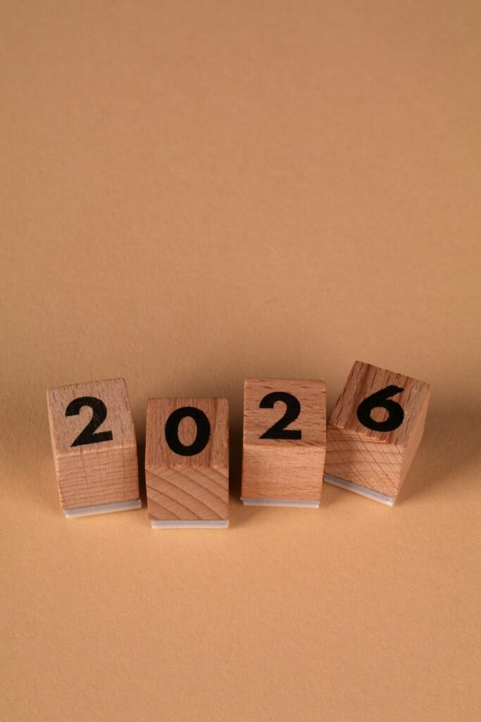 Wooden blocks forming the year 2026 on a warm beige background, symbolizing the new year.